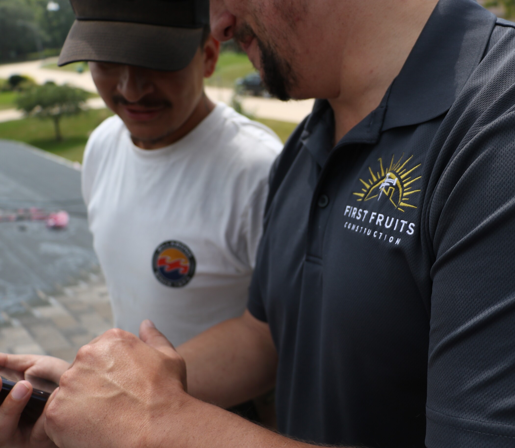 First Fruits Construction logo on shirt of two team members